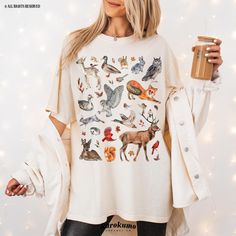 This Unisex garment-dyed t-shirt features a gorgeous watercolor collage of forest animals! It is the perfect gift for nature lovers, environmentalists, wildlife vets and more <3 Make sure to check out the other garment options below :) » O P T I O N S « ‣ Crewneck: https://www.etsy.com/listing/1142792458 » A B O U T « ‣ This item is made to order using direct-to-garment (DTG) printing technology. This digital process involves the printer inks being jetted or sprayed onto the textile by a print head after the garment goes through a pre-treatment machine to create a stronger bond between garment fibers and the pigmented inks. ‣ This is NOT screen printed NOR do we use heat transfer vinyl (iron-on). ‣ The garment is dyed after it's been constructed, giving it a soft color and texture. » S I Z Forest Print Clothes, Woodland Theme Shirts, Girl Camping, Respect The Locals, Camping Clothes, Watercolor Collage, Watercolor Forest, Animal Graphic Tee, Animal Graphic