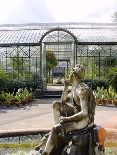 a statue is sitting in the middle of a garden