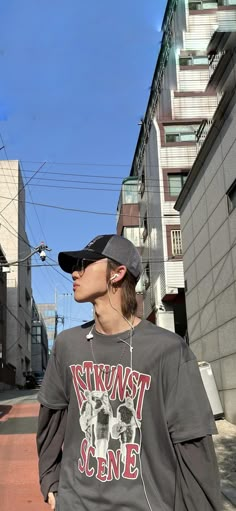 a young man is walking down the street wearing headphones