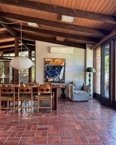 a dining room with red brick flooring and wooden ceiling