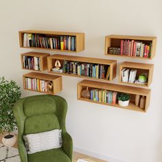 a green chair sitting in front of a book shelf filled with books