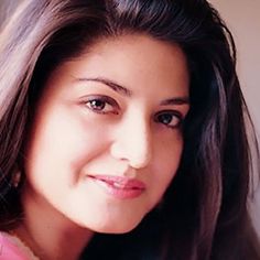 a woman with long brown hair smiling at the camera