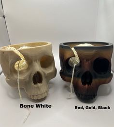 two different types of skull vases sitting next to each other on a white surface