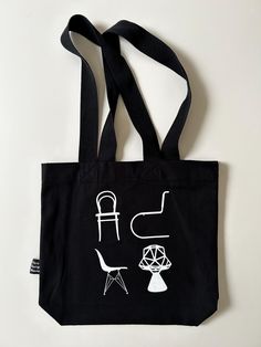 | Description |  Modern Vitra Design Museum black "Atlas of Furniture Design" canvas tote bag.  Tote is black with chair graphic on one side and black straps.  Great for everyday use or grocery shopping!  Bag is in excellent condition with light wear.  There are no holes or tears.  Side has "Vitra Design Museum" tag. | Approximate Size | tote: 15" W x 14" H x 3 3/4" D x 13"L straps | Disclaimer | Please read the description and review photos thoroughly, as all sales are final.  Please read shop policies for full details.  Please message me with any additional questions.  All items are used/vintage and have wear consistent with age. Black Canvas Shoulder Bag For Daily Life, Black Cotton Canvas Bag With Adjustable Strap, Black Cotton Shoulder Bag For Daily Life, Modern Black Cotton Shoulder Bag, Modern Black Canvas Bag With Adjustable Strap, Black Canvas Tote Bag For Daily Use, Black Cotton Bag With Graphic Print, Black Tote Canvas Bag For Daily Use, Black Tote Canvas Bag For Daily Life