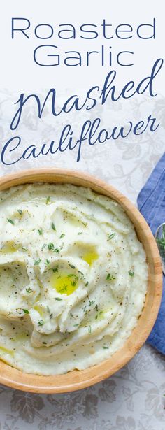 roasted garlic mashed cauliflower in a wooden bowl with a blue napkin on the side