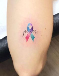 a woman's leg with a tattoo on it that reads power and has a colorful ribbon