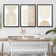 three framed art prints on the wall above a dining room table