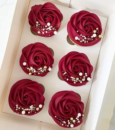 six cupcakes in a white box decorated with red roses and pearls