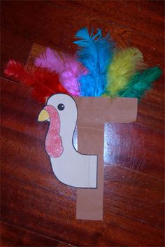 the letter f is made out of paper with feathers on it's head and in the shape of a turkey