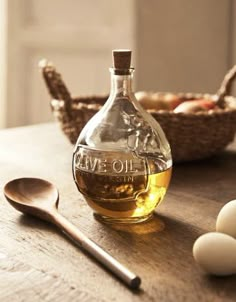 a bottle of olive oil next to some eggs