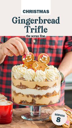 a person decorating a gingerbread trifle cake on a table with cookies and candy