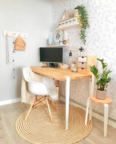 a room with a desk, chair and potted plant