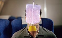 a man with a plastic bag on his head holding a yellow object in front of his face