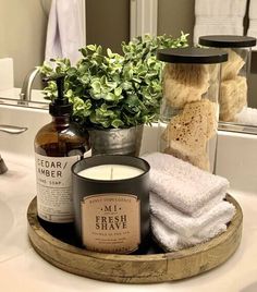 a bathroom sink with soap, candles and towels