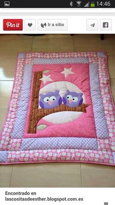 a pink and purple quilt with two owls on it