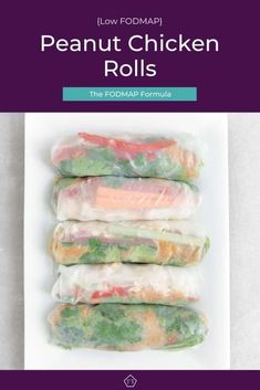 four rolls with meat and vegetables wrapped in plastic wrappers on top of a white plate