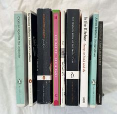 a row of books sitting on top of a white bed sheet next to each other