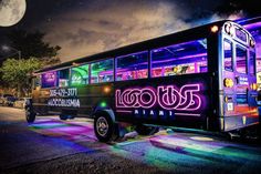 a colorful bus is parked on the side of the road in front of a full moon