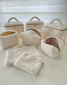 six white purses with matching blankets on them