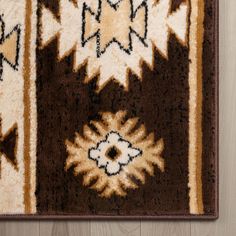 a brown and white area rug on top of a wooden floor next to a wall