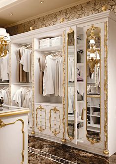 a white and gold closet with clothes on it