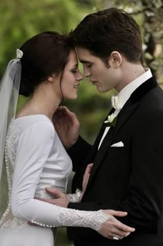 a man in a tuxedo standing next to a woman wearing a wedding dress