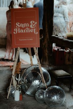 Orange and white wedding welcome sign on a wooden easel with disco ball decor and dried flowers for rustic glam wedding Wedding Welcome Sign Disco Ball, Boho Disco Wedding Decor, Disco Wedding Welcome Sign, Disco Rehearsal Dinner, Retro Wedding Welcome Sign, Disco Welcome Sign, Rustic Disco Wedding, Disco Theme Wedding Decor