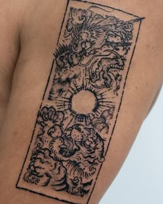 a tattoo on the back of a woman's shoulder with an image of a sun and clouds