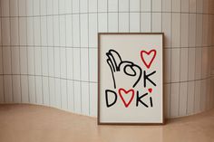 there is a picture frame with the word doki on it next to a tiled wall