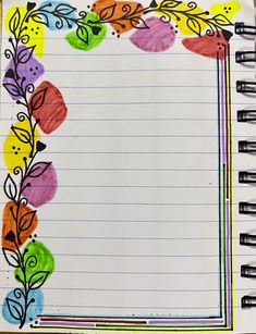 an open notebook with colored leaves and lines drawn on the paper in front of it