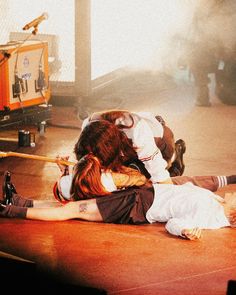 two people laying on the ground in front of a fire hydrant with their arms around each other