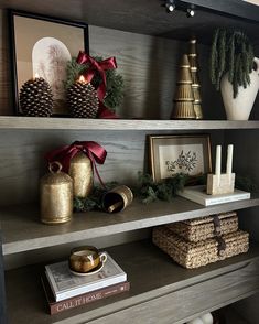a shelf with christmas decorations and other items on it, including pine cones, candlesticks