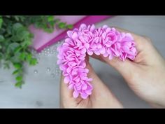 a person is holding pink flowers in their left hand and green leaves on the right