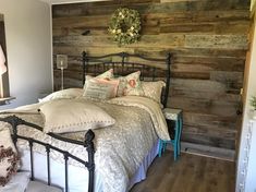 a bed sitting in a bedroom next to a wall with wooden planks on it