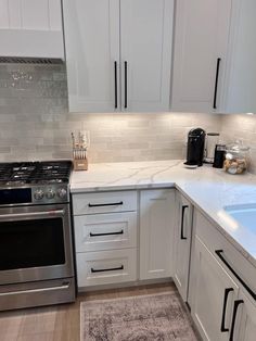 a kitchen with white cabinets and stainless steel appliances