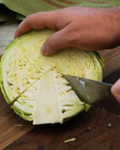 someone cutting up an artichoke with a knife