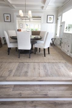 a dining room table with white chairs around it