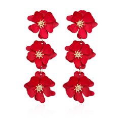 three red flowers hanging from the side of a pair of earrings