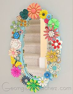 a mirror that has flowers on it in the shape of a flower and leaves frame