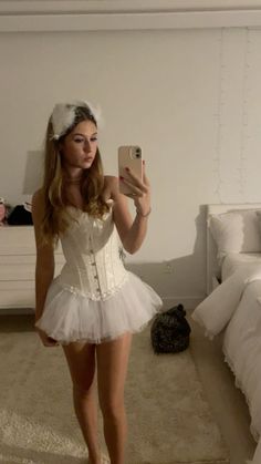 a woman in a white corset taking a selfie with her cell phone