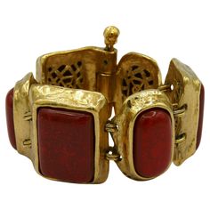 YVES SAINT LAURENT vintage articulated cuff bracelet featuring large rectangular and oval faux coral resin cabochons in a textured gold tone setting. Marked YSL Made in France. Indicative measurements : length approx. 17.5 cm (6.89 inches) / rectangular links width approx. 3.7 cm (1.46 inches). Material : Gold tone metal hardware / Resin. NOTES - This is a preloved vintage item, therefore it might have imperfections. - Colors may differ slightly from actual product appearance due to differences Ysl Vintage, Saint Laurent Vintage, Couture Mode, Gold Texture, Metal Hardware, Red And Gold, Gold Tone Metal, Cuff Bracelet, Christian Dior