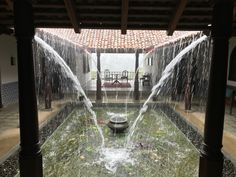 an indoor fountain with water spouting from it's sides in a courtyard