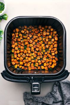 cooked tofu cubes in an air fryer with parsley on the side