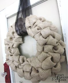 a wreath hanging on the side of a door with a long black hair sticking out of it