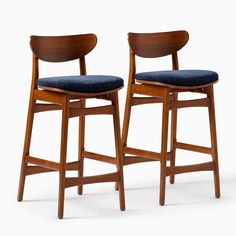 two wooden stools with blue upholstered seat cushions, one on each side