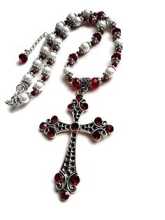 Wonderfully capturing the essence of the Renaissance Tudor style with a very elaborate design this OOAK ox blood red and white pearl cross necklace graces the neck with Victorian elegance. A unique statement timeless piece of jewelry with a royal feel. A glamorous bridal choker necklace for a Gothic wedding. Shimmering with a rich crimson red glow, this dazzling intricate pendant necklace with a delightful vintage appeal and flashing sparkles with every movement features an absolutely stunning a Elegant Red Cross Pendant Jewelry, Victorian Cross Necklace, Pearl Necklace Outfit, Baroque Jewelry, Pearl Cross Necklace, Victorian Elegance, Necklace Outfit, Large Pendant Necklace, Bridal Choker