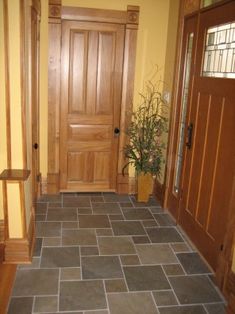 an entryway with tile flooring and wooden doors, along with potted plant