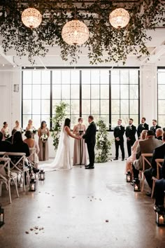 a bride and groom standing at the end of their wedding ceremony in front of an audience