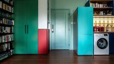 the laundry room is brightly colored and has bookshelves, cabinets, and a washing machine