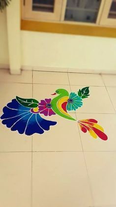 a colorful flower design on the floor in front of a window with a potted plant next to it